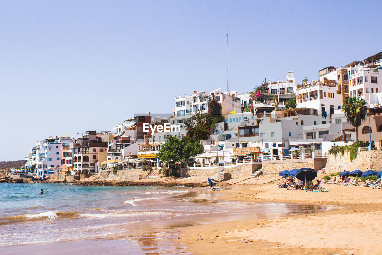 BUILDINGS ON BEACH AGAINST CLEAR SKY