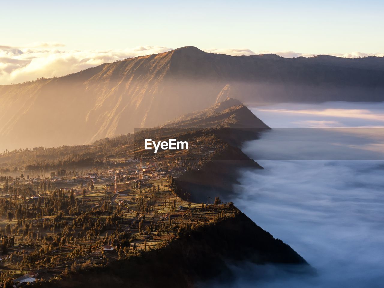 Scenic view of sea against mountains during sunset