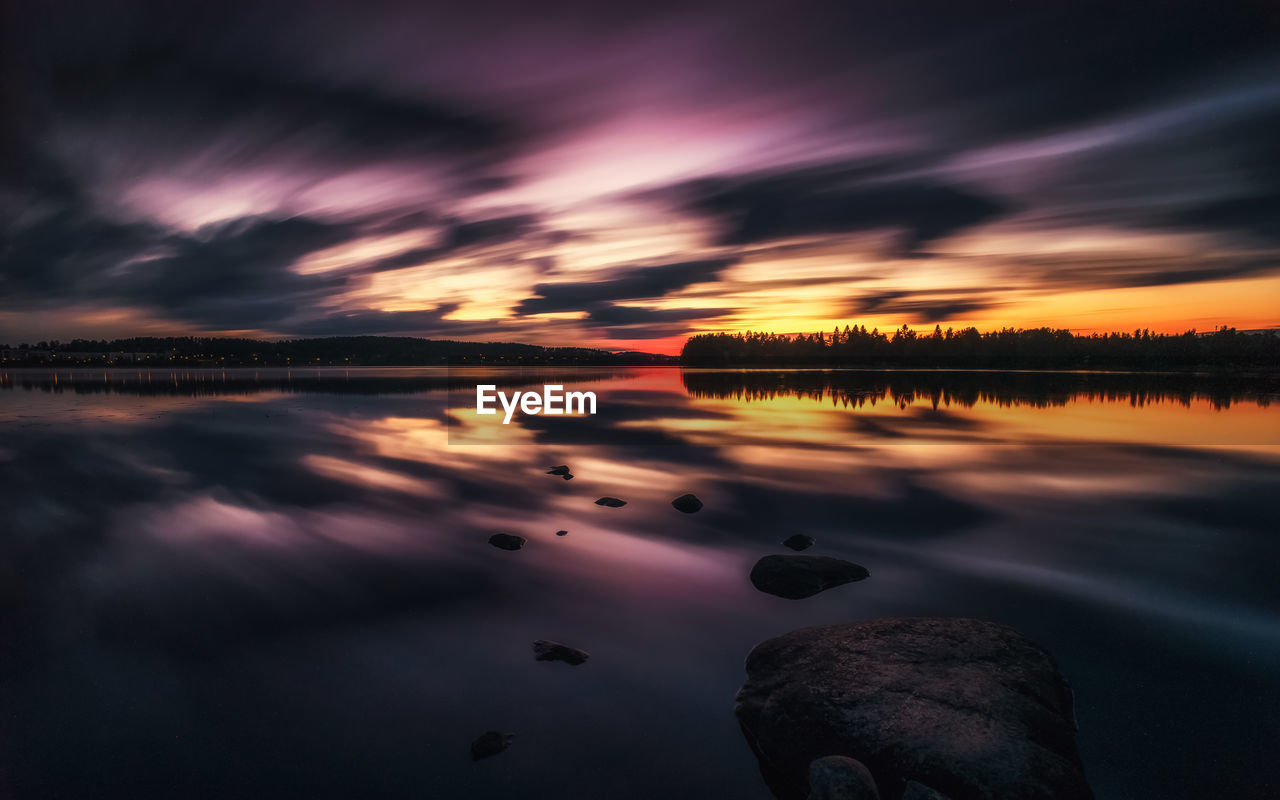 REFLECTION OF SKY ON LAKE DURING SUNSET