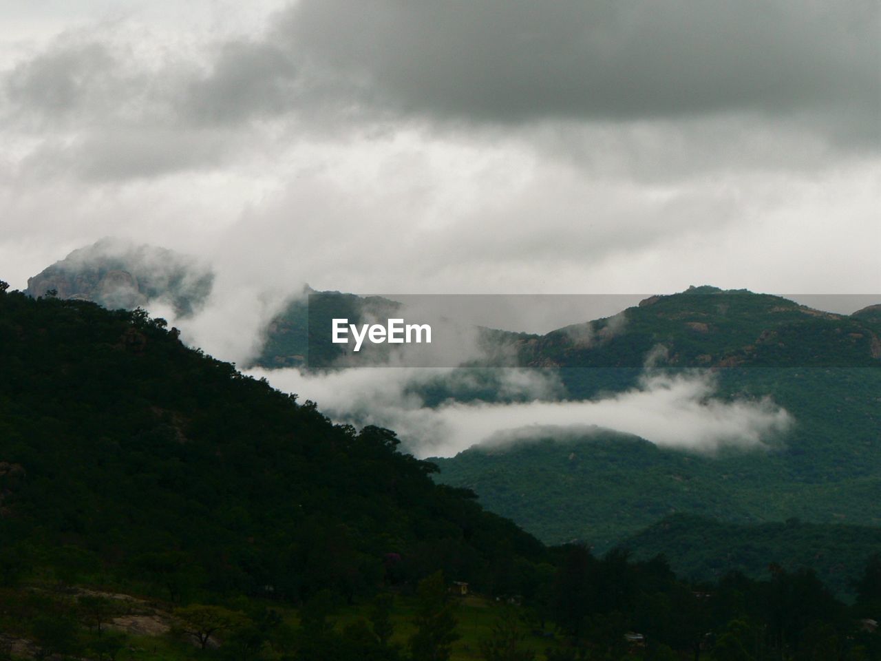 Scenic view of mountains against cloudy sky