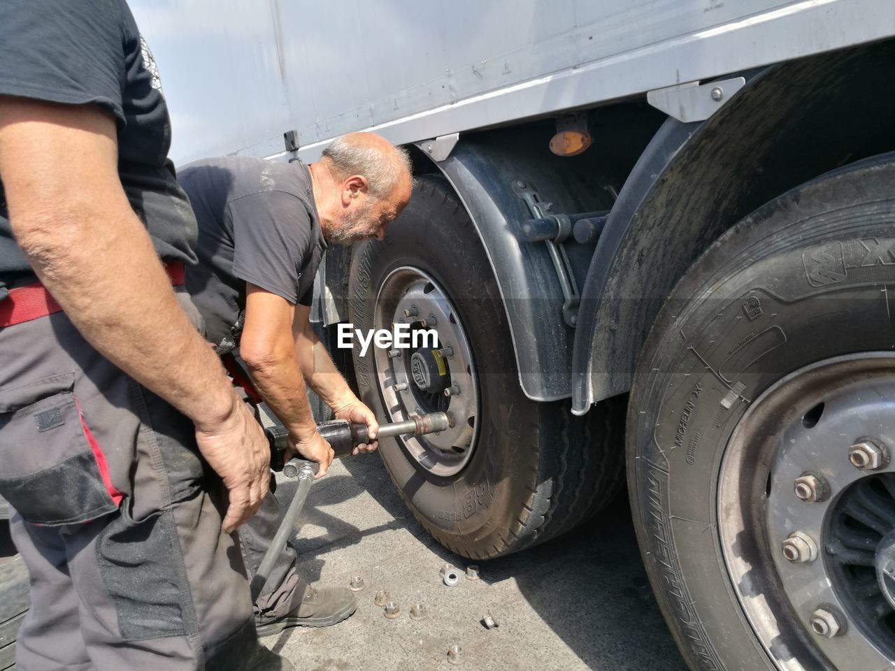 Manual worker inflating semi-truck tire