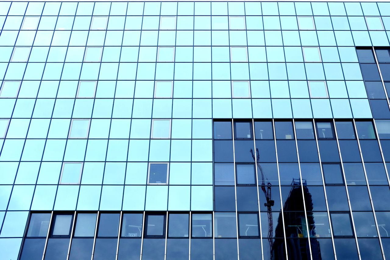 LOW ANGLE VIEW OF MODERN BUILDING AGAINST BLUE SKY