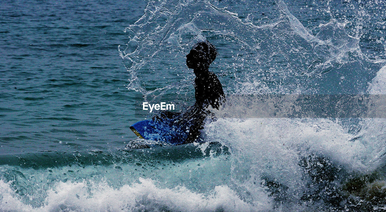 SILHOUETTE MAN SWIMMING IN SEA AGAINST SKY