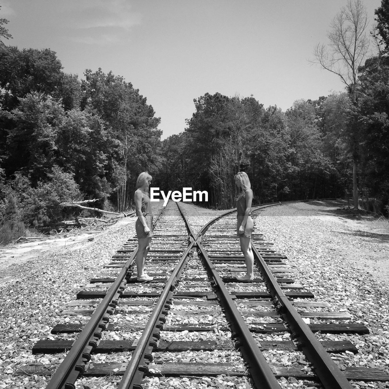 Two women standing on railroad track