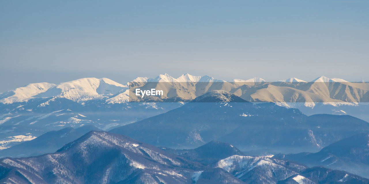 Scenic view of snowcapped mountains against clear sky
