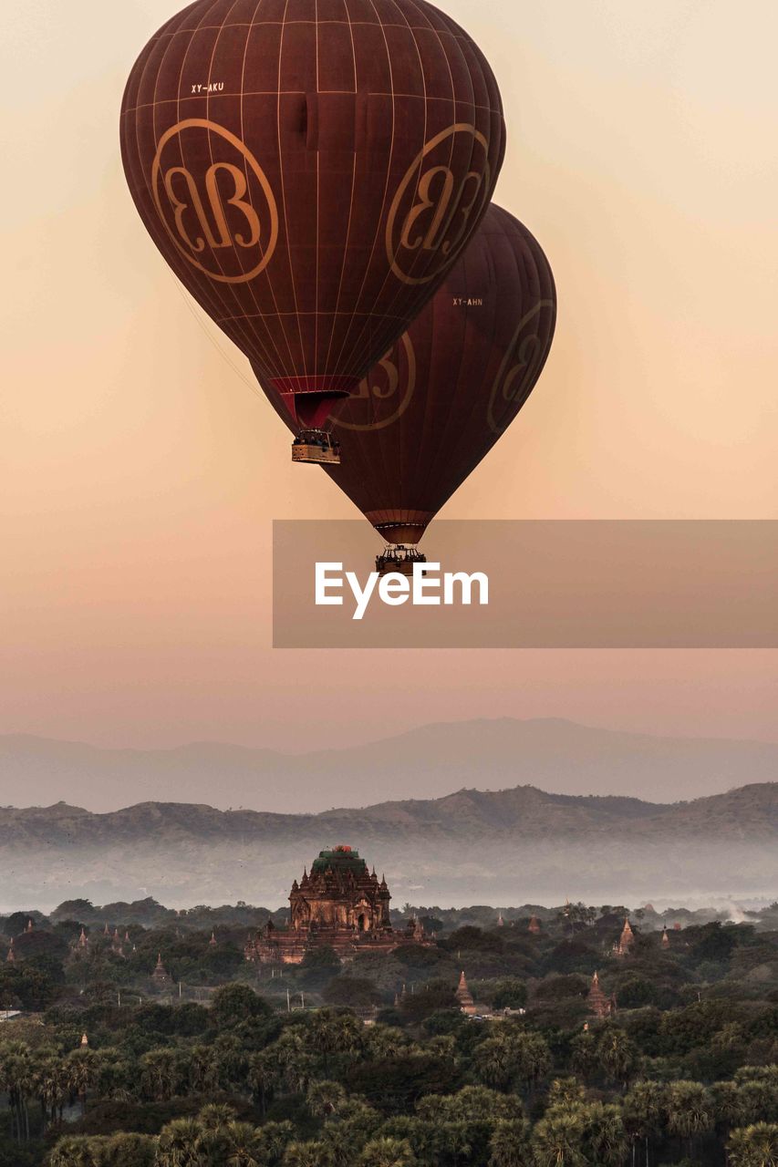 VIEW OF HOT AIR BALLOON FLYING OVER MOUNTAIN AGAINST SKY
