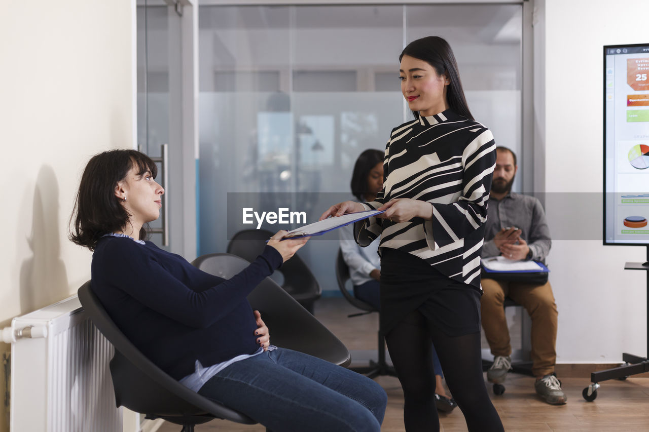 Side view of pregnant woman sitting at office