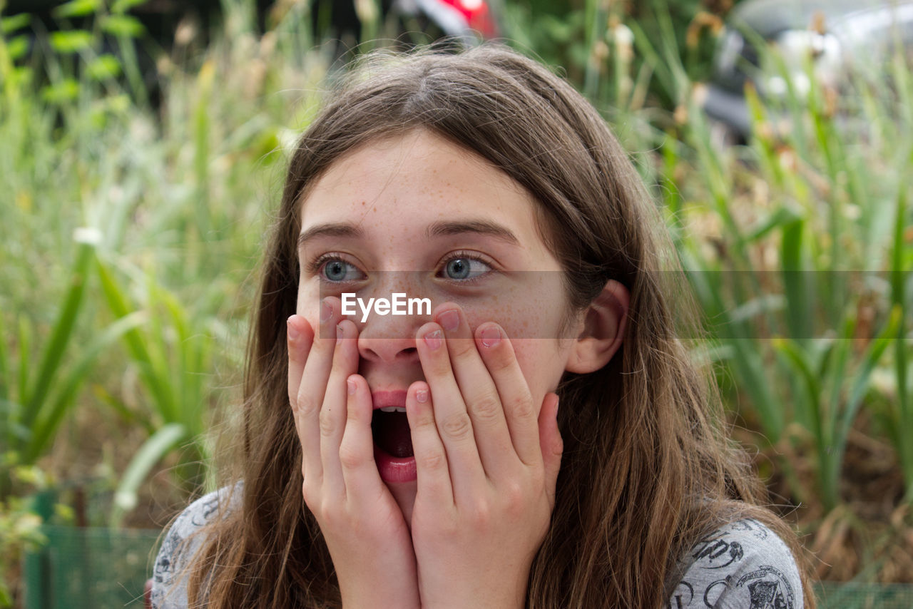 Close-up of surprised young woman looking away