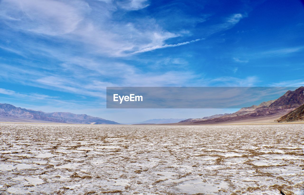 landscape, environment, sky, scenics - nature, mountain, nature, beauty in nature, land, cloud, natural environment, desert, horizon, blue, mountain range, no people, travel destinations, travel, tranquility, climate, tranquil scene, plateau, non-urban scene, arid climate, sea, day, extreme terrain, outdoors, snow, sand, dry, wilderness, barren, valley, semi-arid, remote, cold temperature, sunlight, tourism, winter, rock