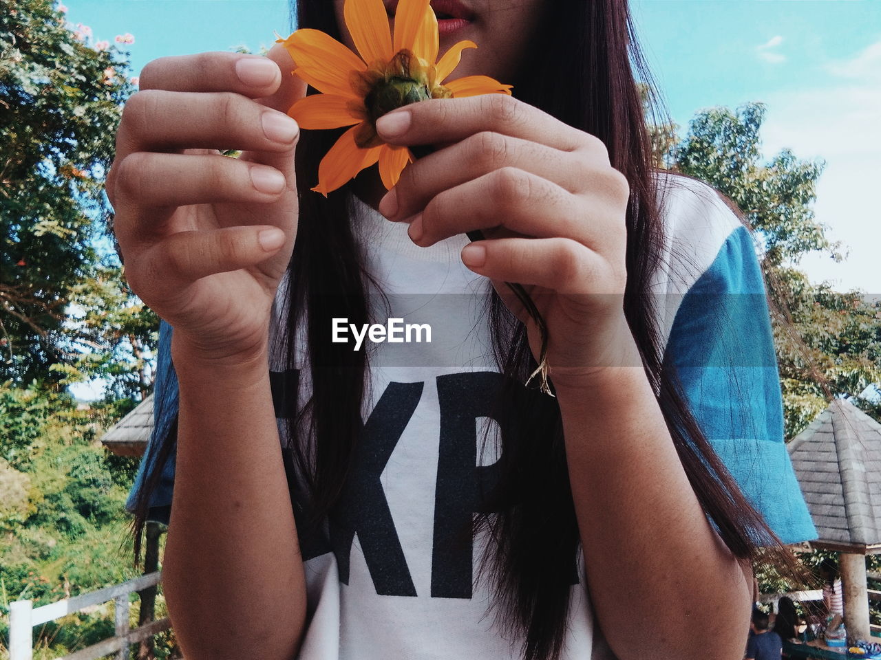 Midsection of girl holding yellow flower