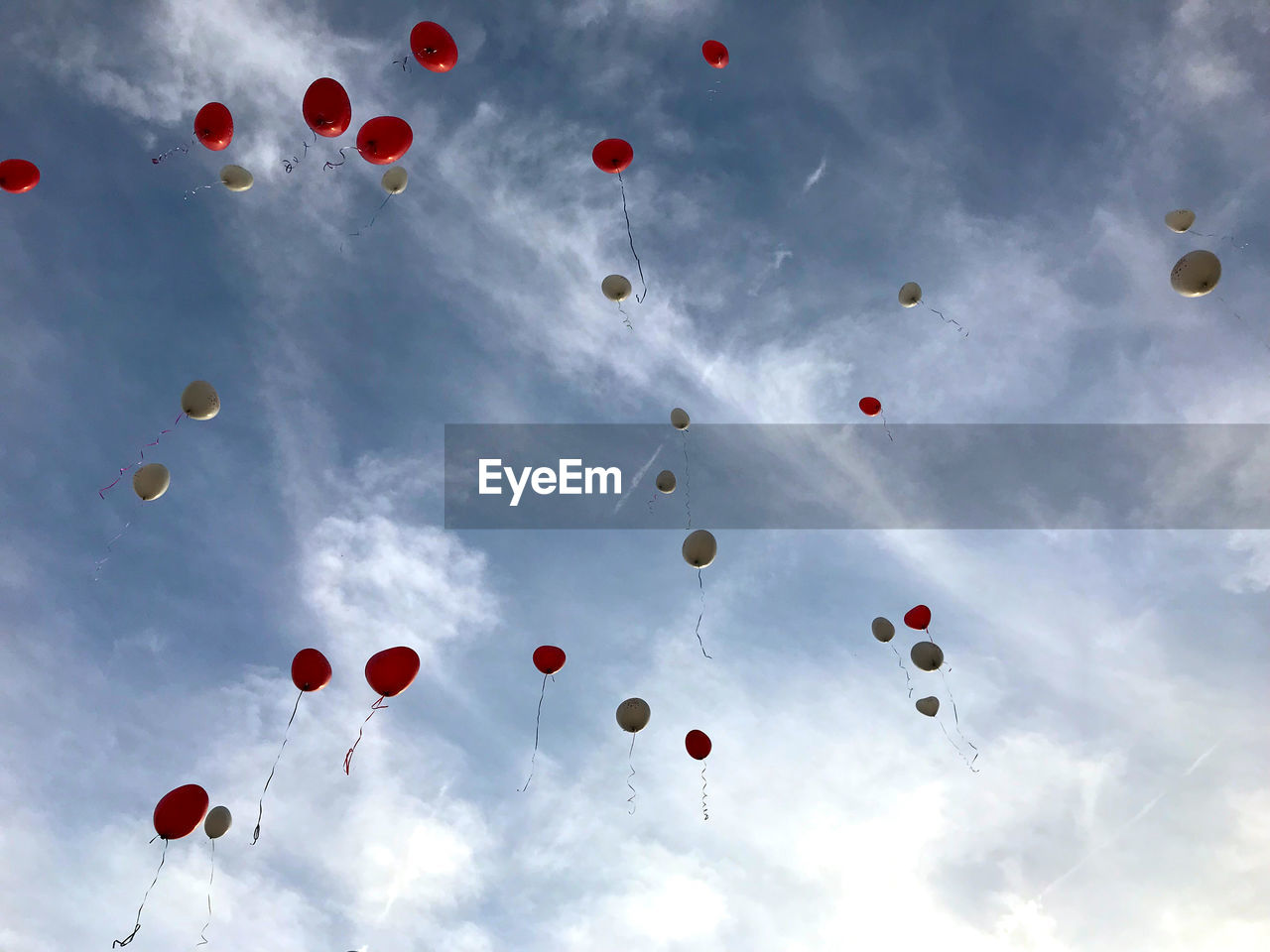 Low angle view of balloons flying against sky