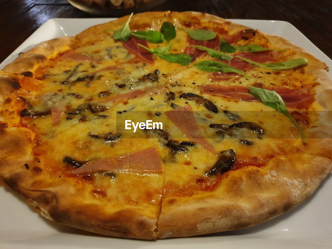 HIGH ANGLE VIEW OF PIZZA SERVED ON TABLE