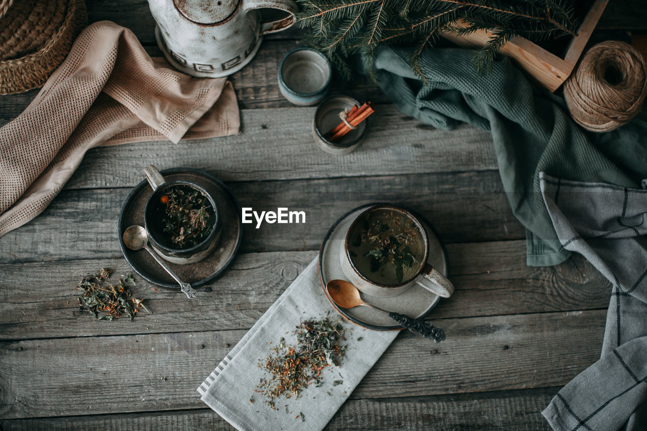 Ceramic mugs with tea on a wooden table, top view