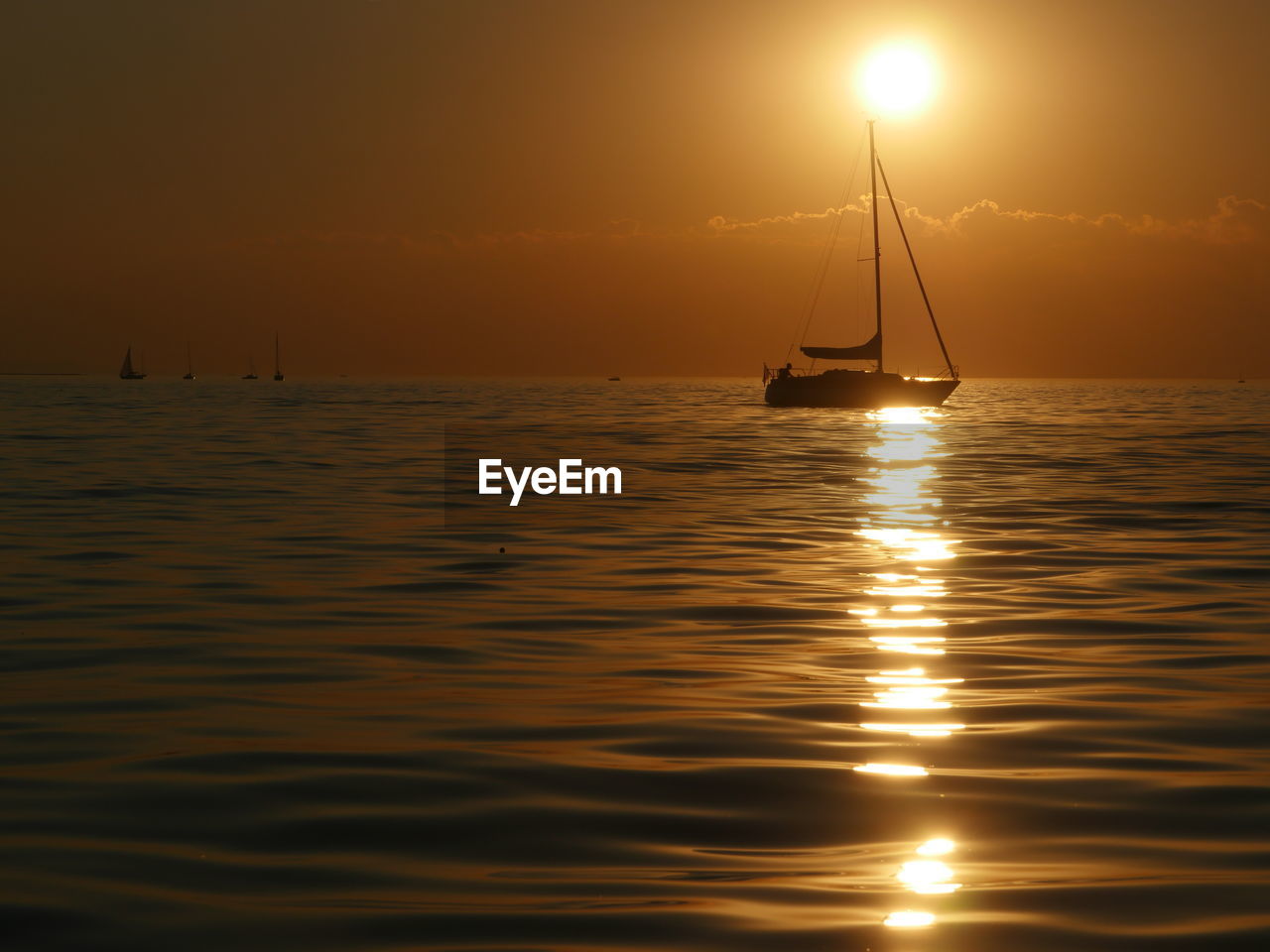 Silhouette sailboat sailing on sea against sky during sunset