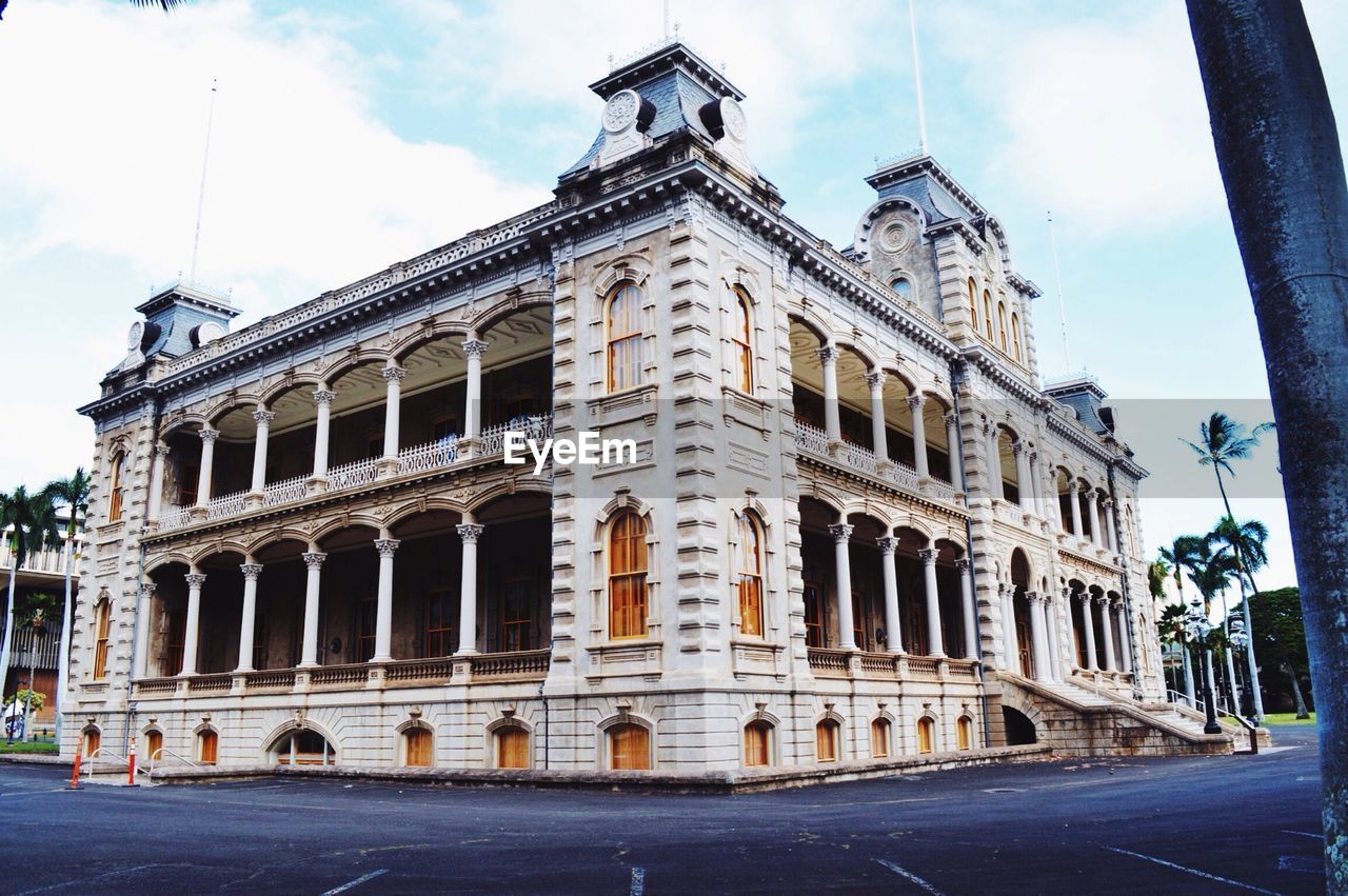 Low angle view of iolani palace by street against sky