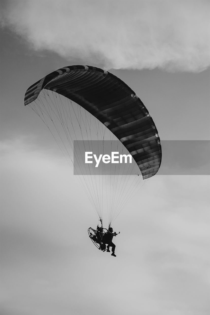 Low angle view of person paragliding against sky