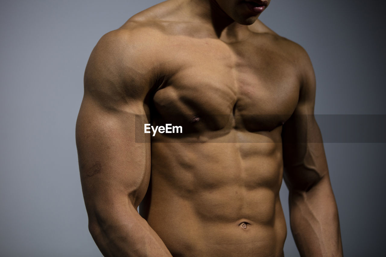 Midsection of shirtless muscular man