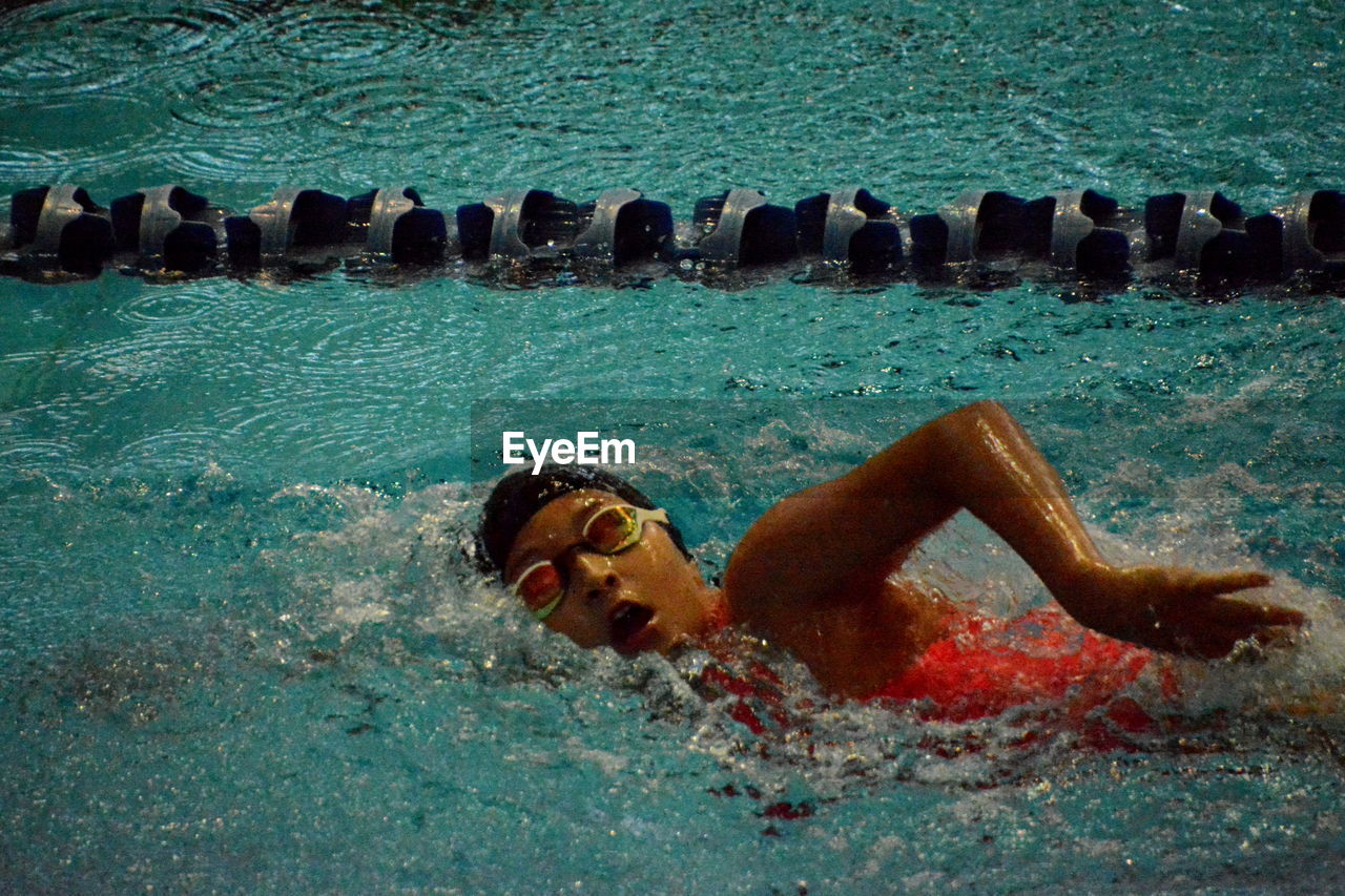 Portrait of shirtless man lying in swimming pool