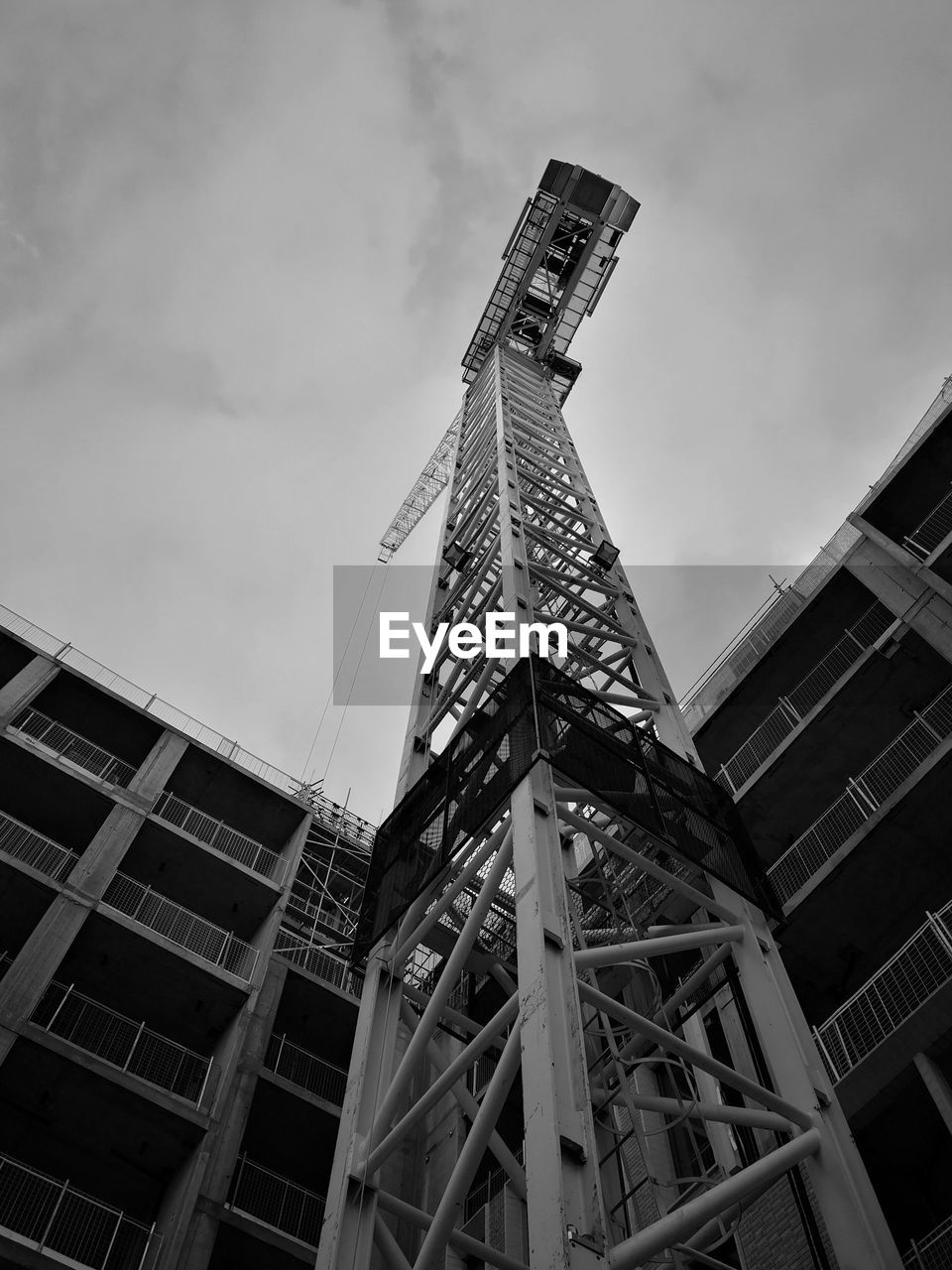 LOW ANGLE VIEW OF CRANE AND BUILDINGS AGAINST SKY