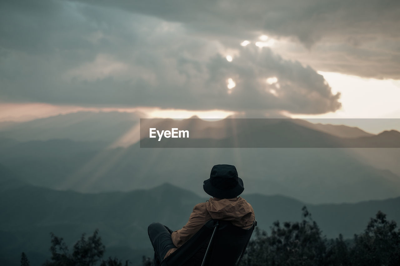 A man was sitting is looking at the sky explosions