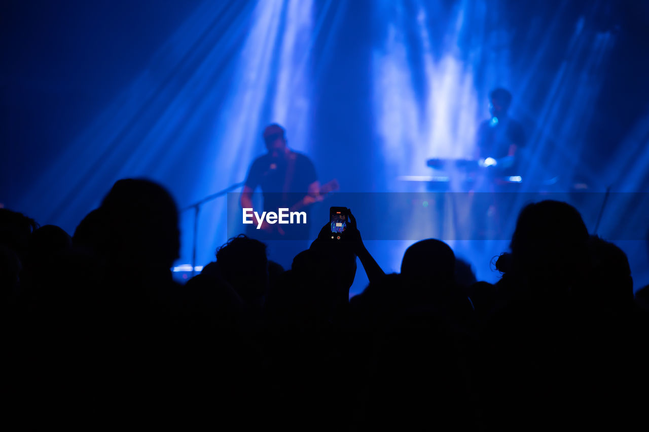 GROUP OF SILHOUETTE PEOPLE AT CONCERT