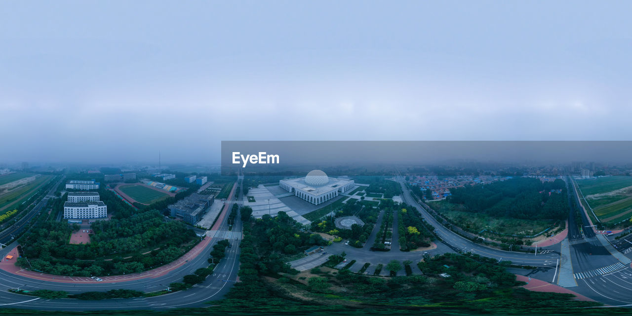 HIGH ANGLE VIEW OF CITYSCAPE AGAINST CLOUDY SKY