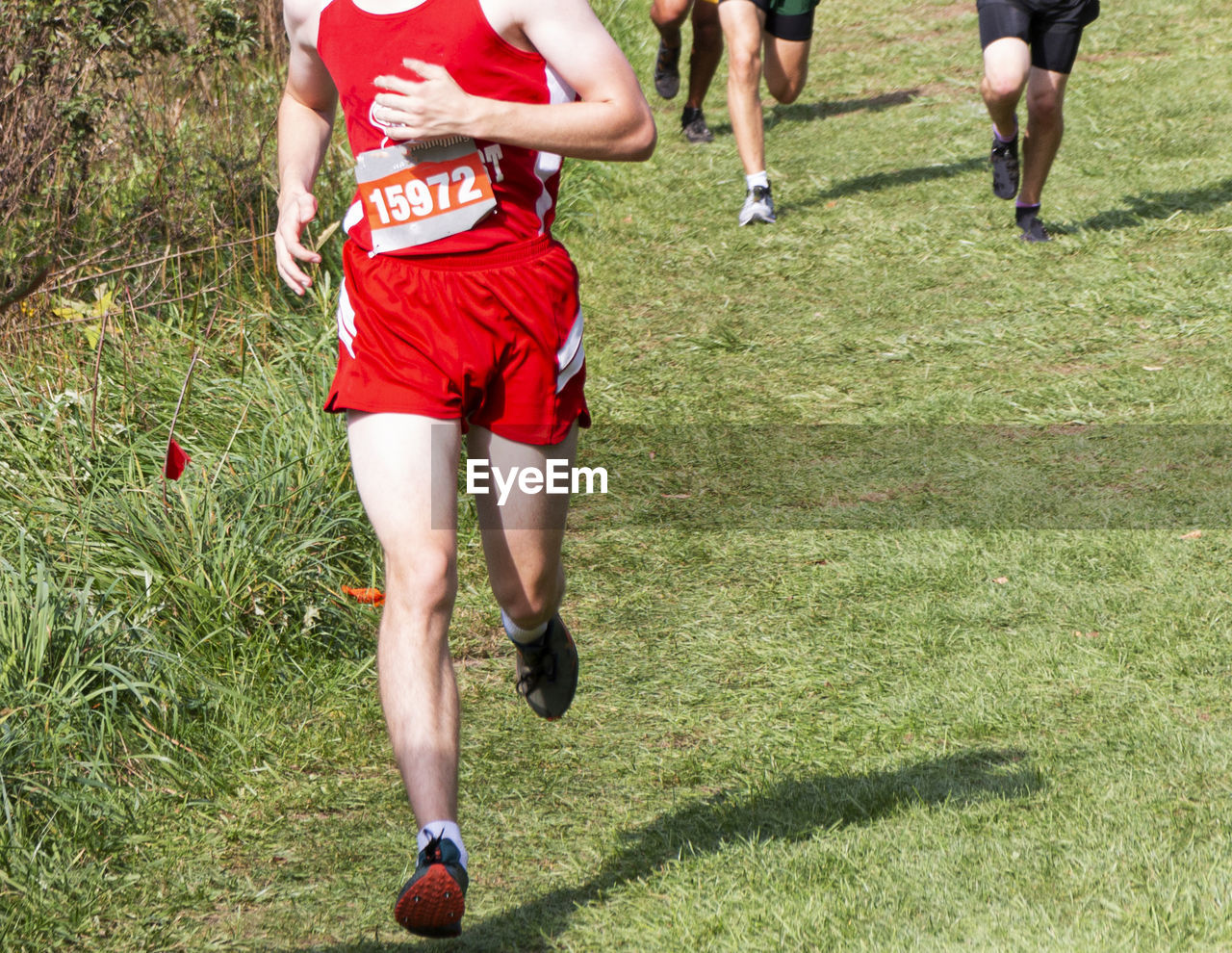 LOW SECTION OF WOMEN RUNNING ON GRASSLAND