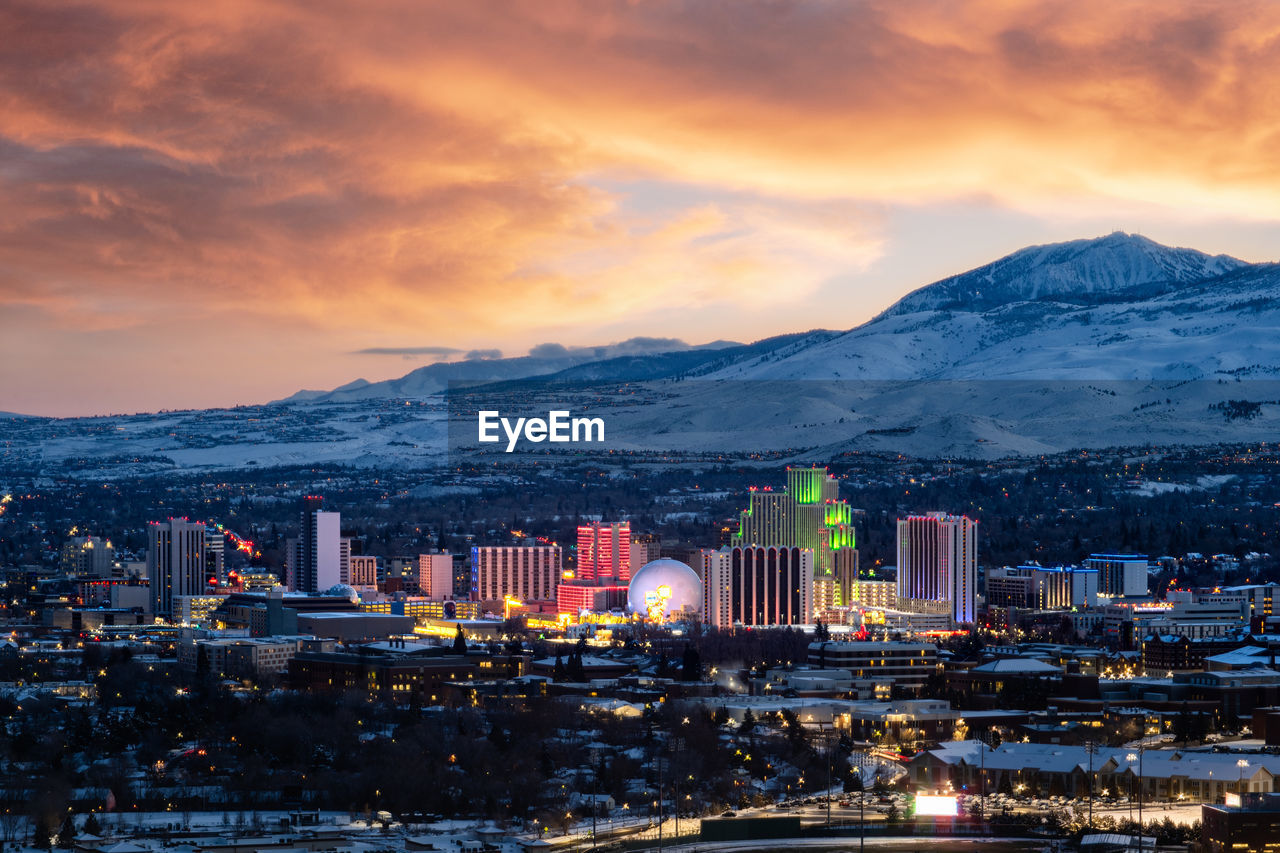 Snowy sunset skyline of reno, nv with snowcapped mountains in the background