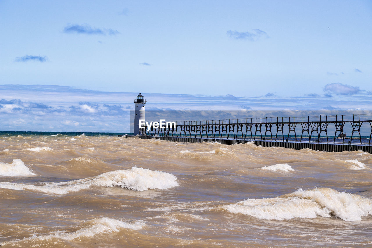 LIGHTHOUSE ON BEACH AGAINST SKY