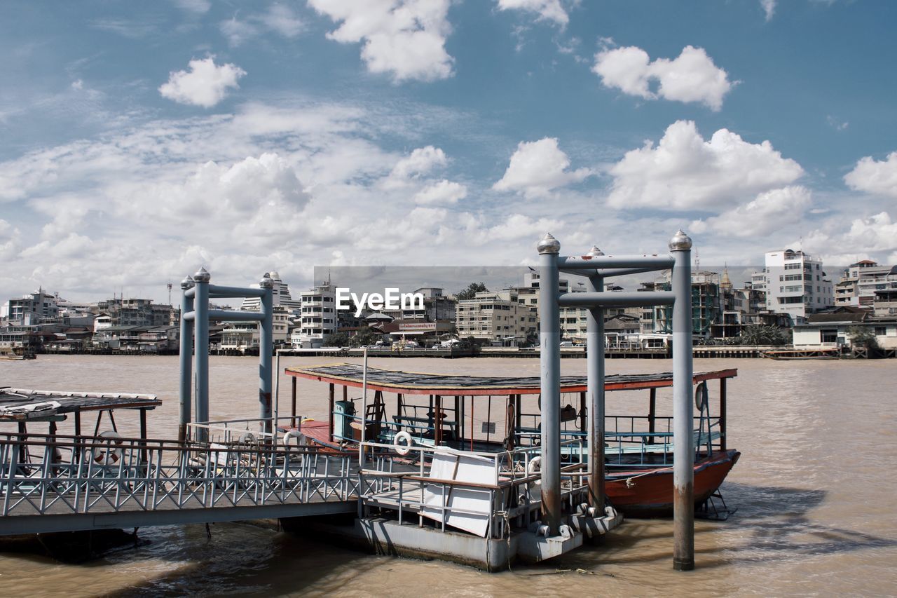 PIER ON RIVER AGAINST SKY IN CITY