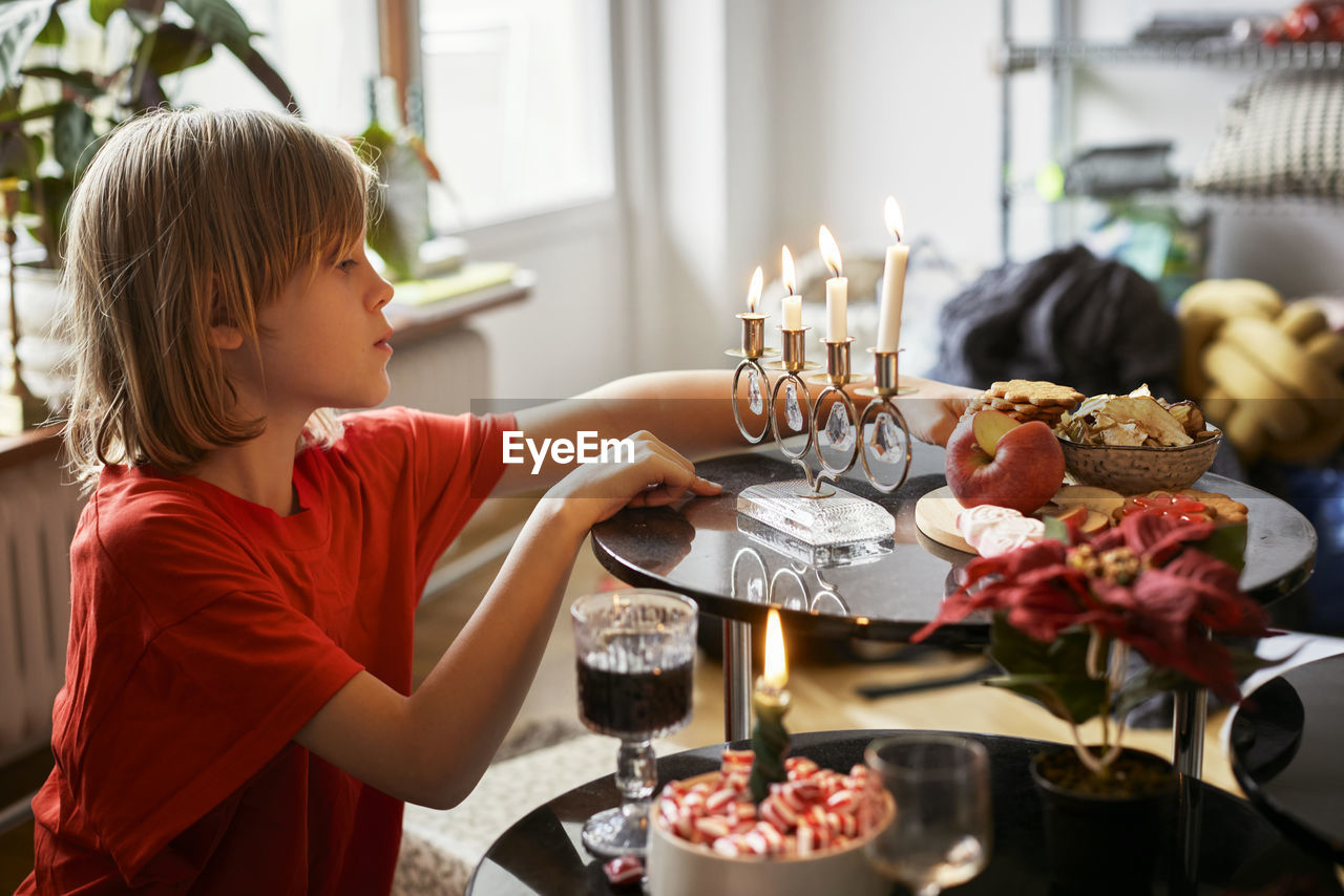Boy sitting at table with christmas food and decorations