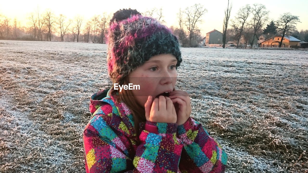 Portrait of girl in snow on field