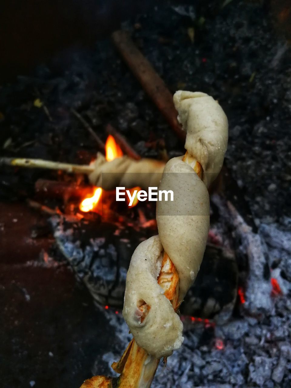 HIGH ANGLE VIEW OF BURNING CANDLES ON LOG