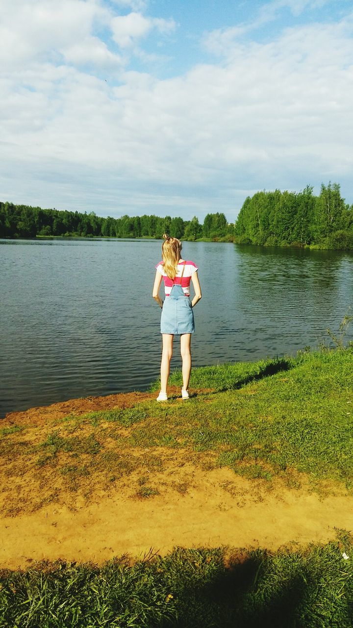 WOMAN STANDING IN LAKE AGAINST SKY