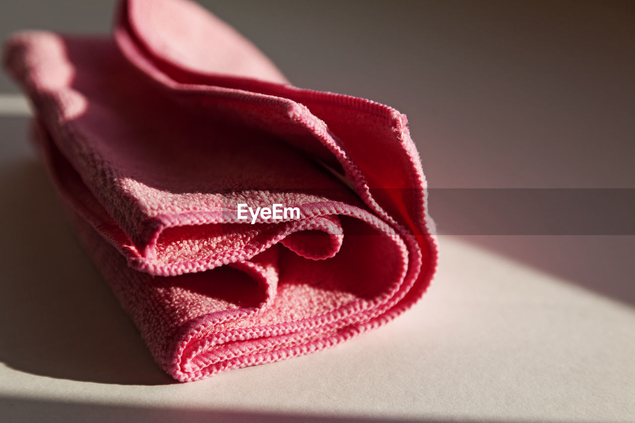 A pink nonwoven cloth lying in the windowsill as the sun goes down