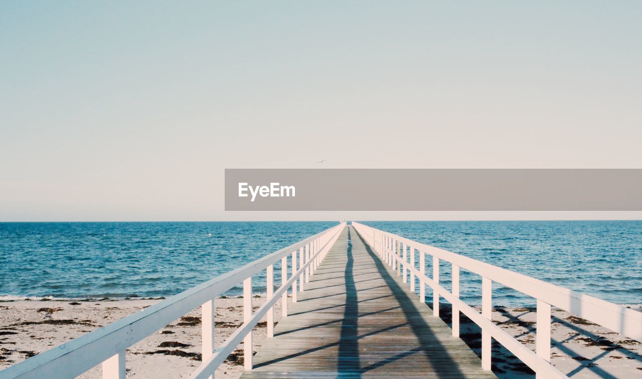 Pier over sea against clear sky