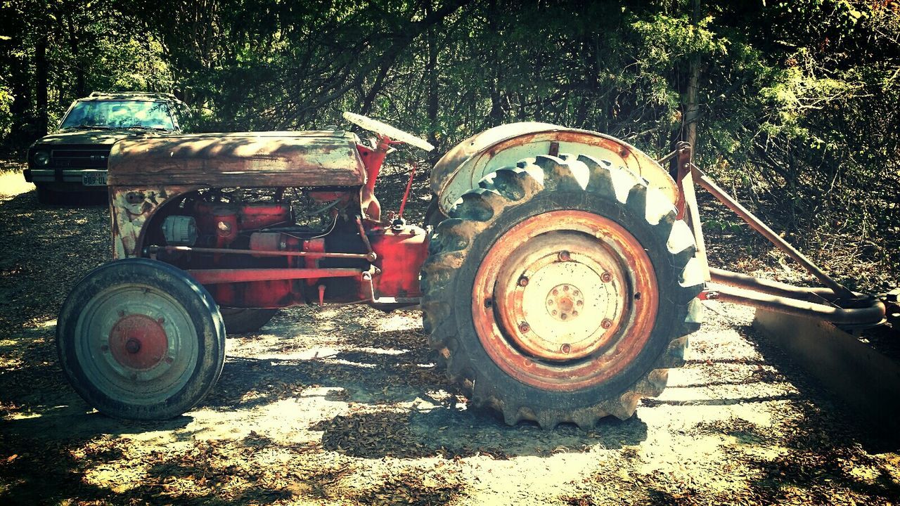 Tractor on field against trees