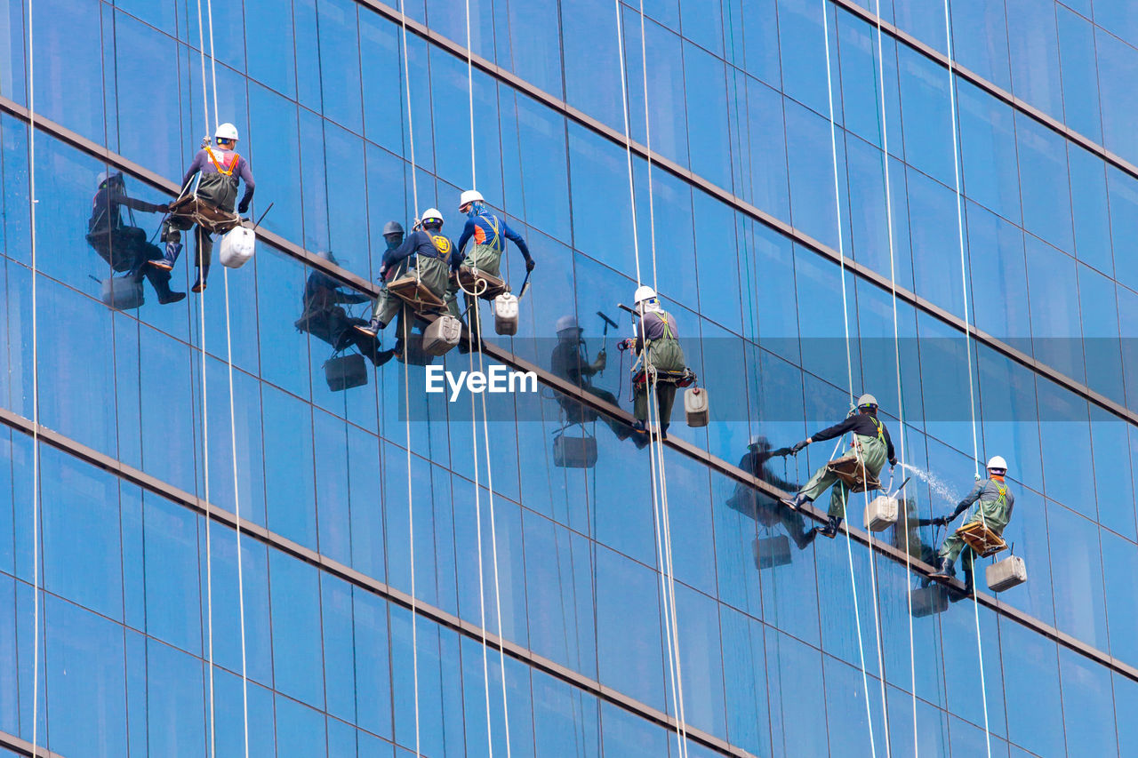 LOW ANGLE VIEW OF PEOPLE WORKING ON ROPES