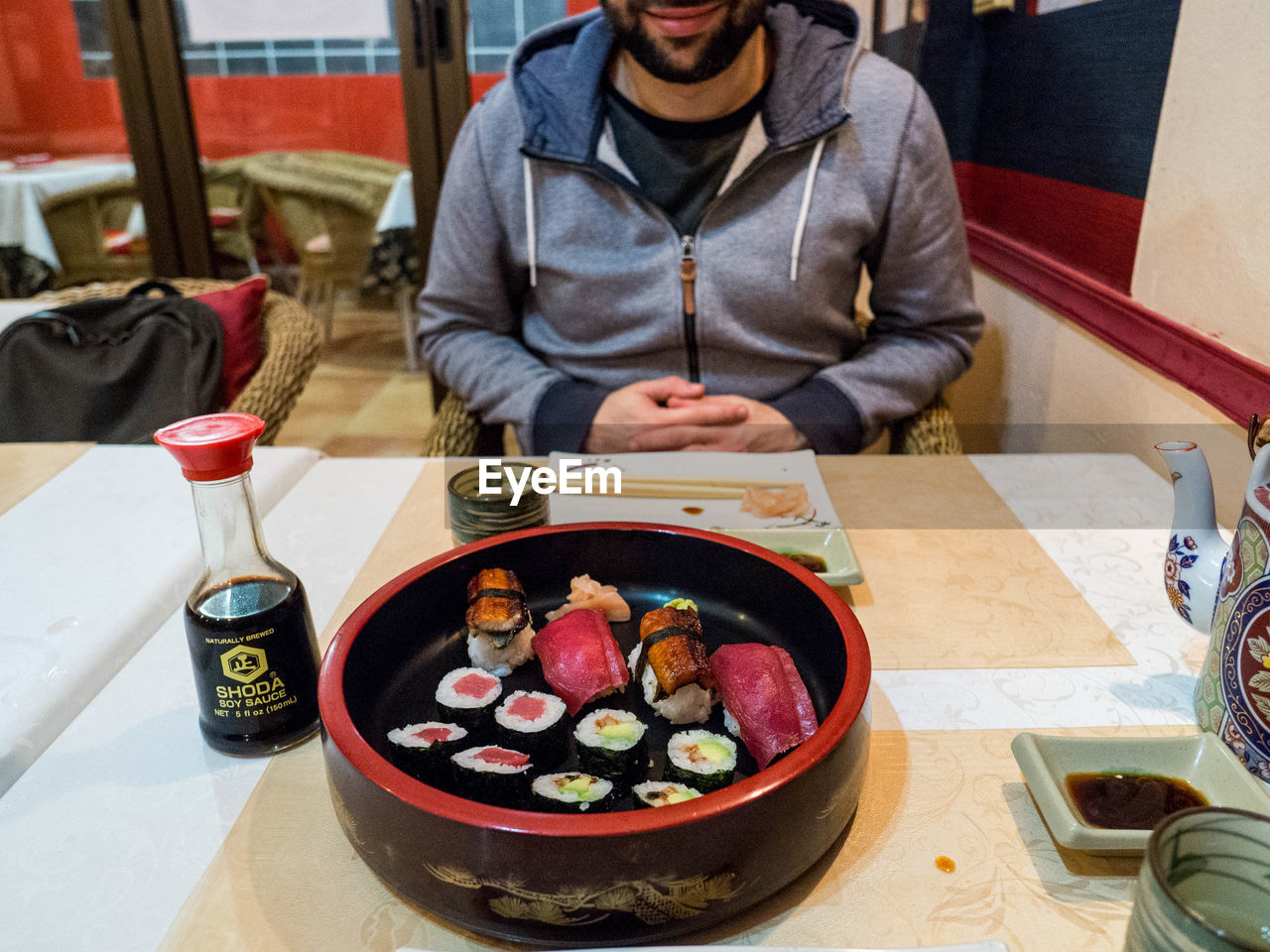 MIDSECTION OF MAN SITTING IN BOWL