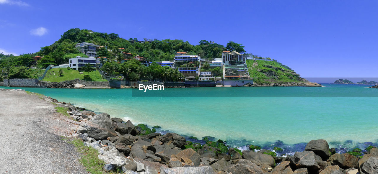 Scenic view of sea and houses against sky