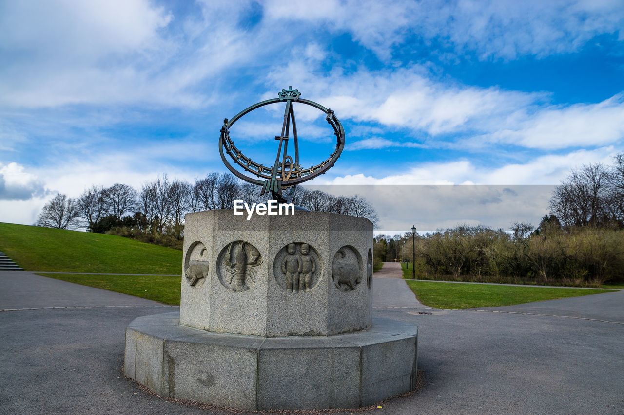 Sundial in vigeland park against cloudy blue sky