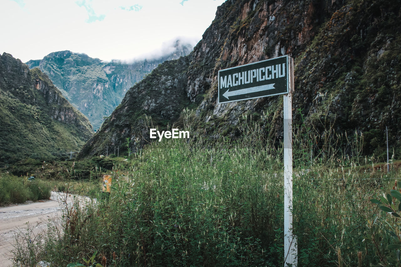 Information sign on field against mountains