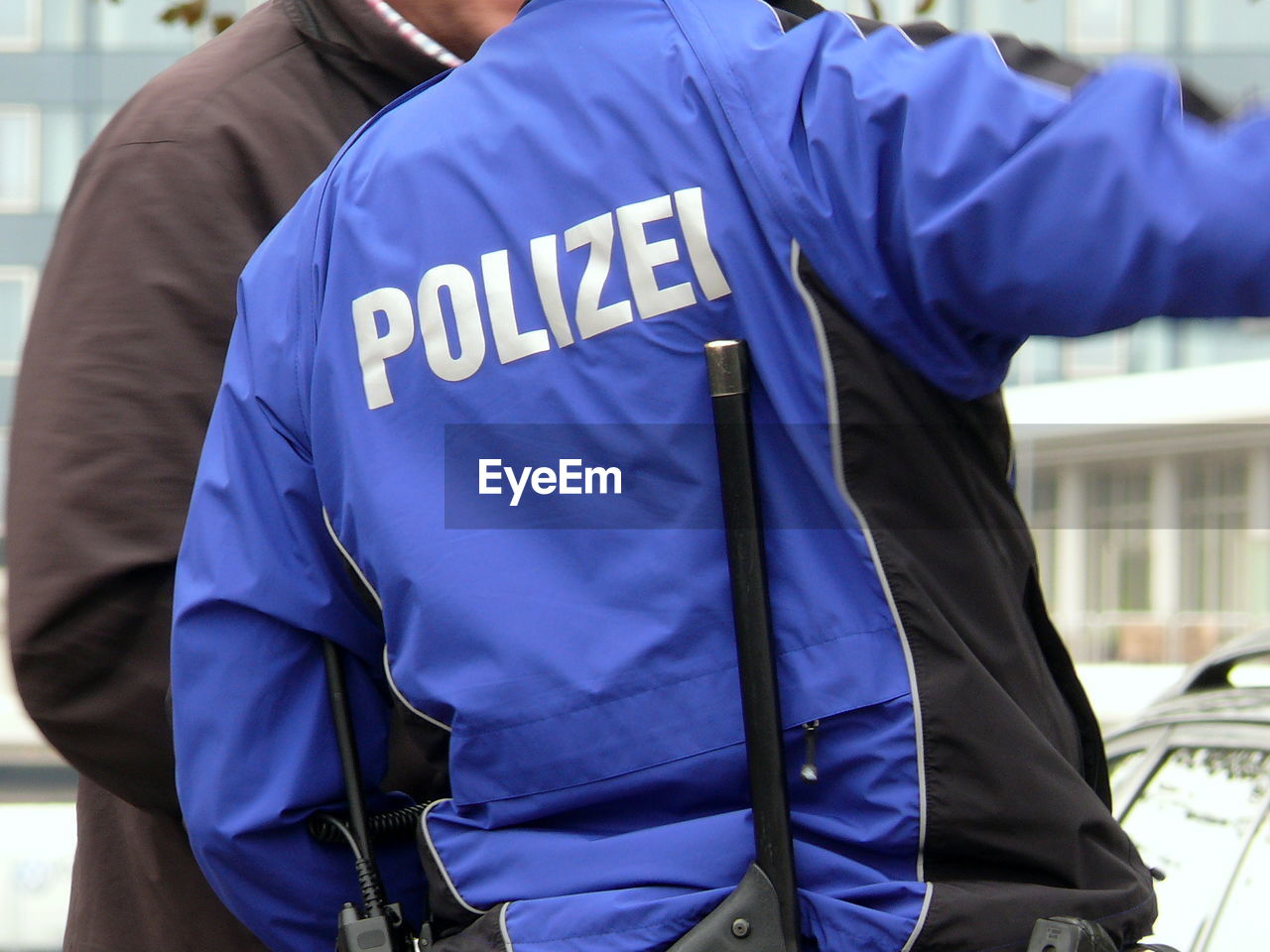 Rear view of police man standing in city