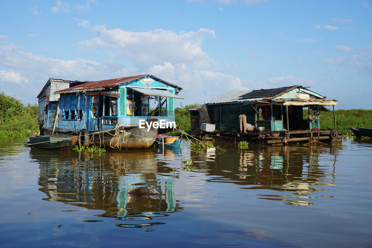 Houses in lake against sky