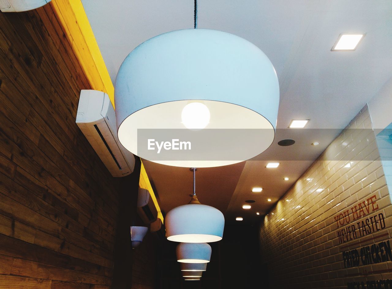 LOW ANGLE VIEW OF ILLUMINATED PENDANT LIGHT HANGING ON CEILING