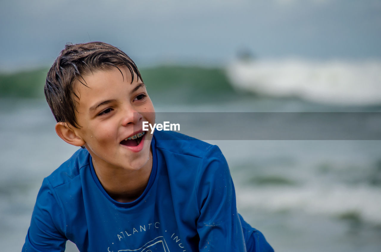 Portrait of smiling boy against sea