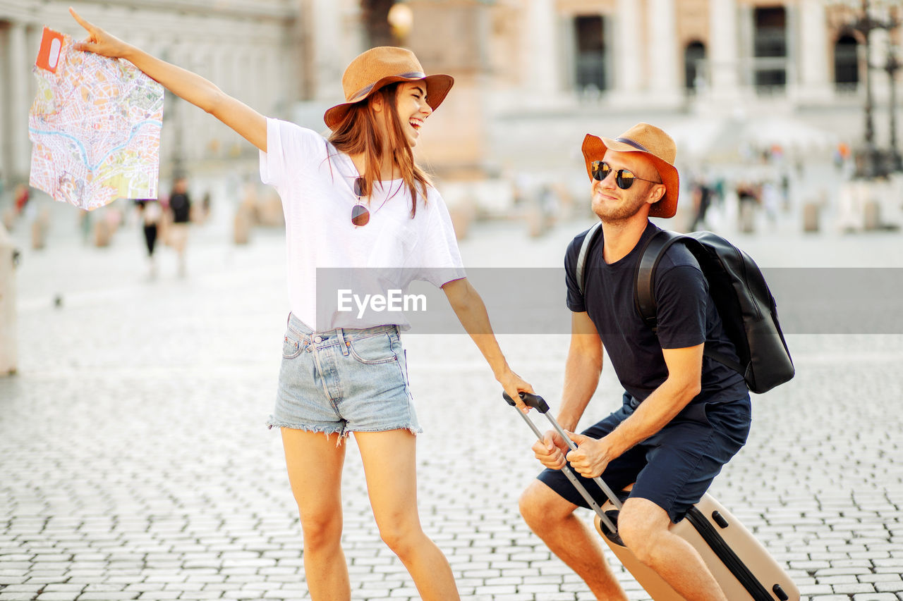 Happy tourists looking at a map and choose a hotel. couple of tourists on vacation in rome, italy. 