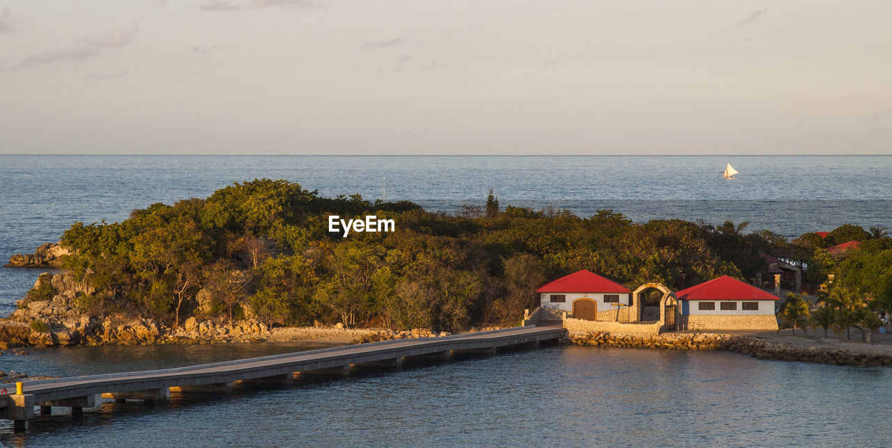 VIEW OF CALM SEA IN FRONT OF BUILT STRUCTURE