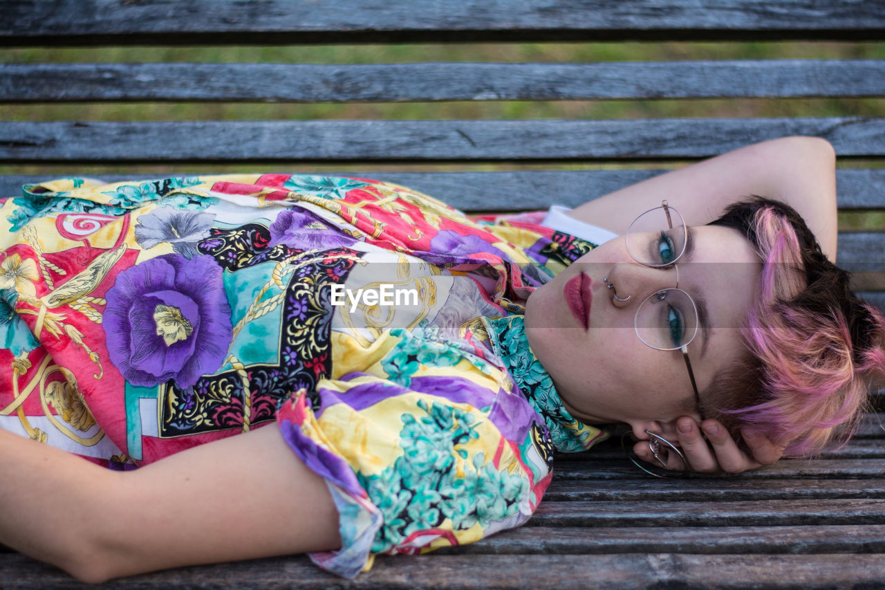 Portrait of young woman lying on bench