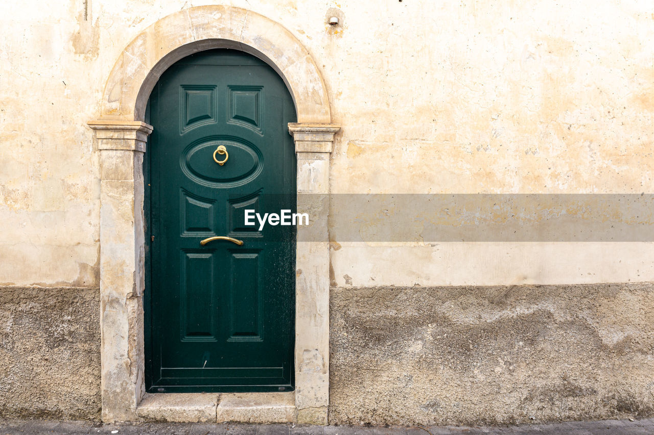 architecture, door, entrance, building exterior, built structure, closed, building, blue, no people, security, day, protection, wall, wall - building feature, residential district, old, house, outdoors, front door, city, door handle, window, doorway, wood, iron, history, arch, facade, the past